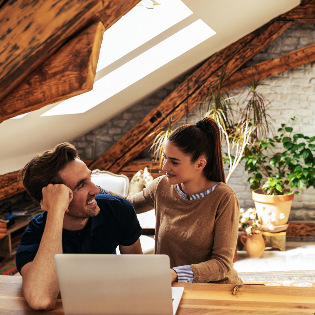 Couple looking at each other with laptop